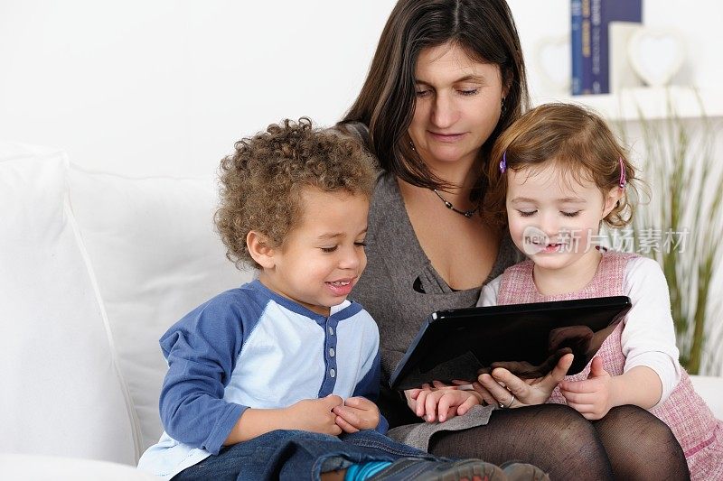 白种人照顾者/母亲/保姆使用数字平板电脑与幼儿